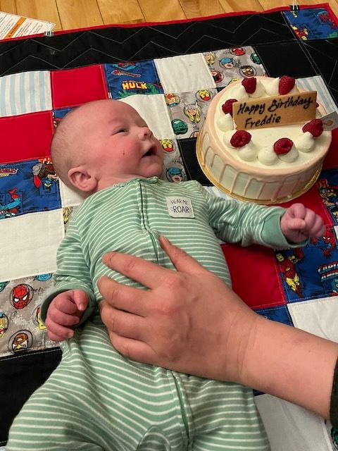 Baby next to a cake