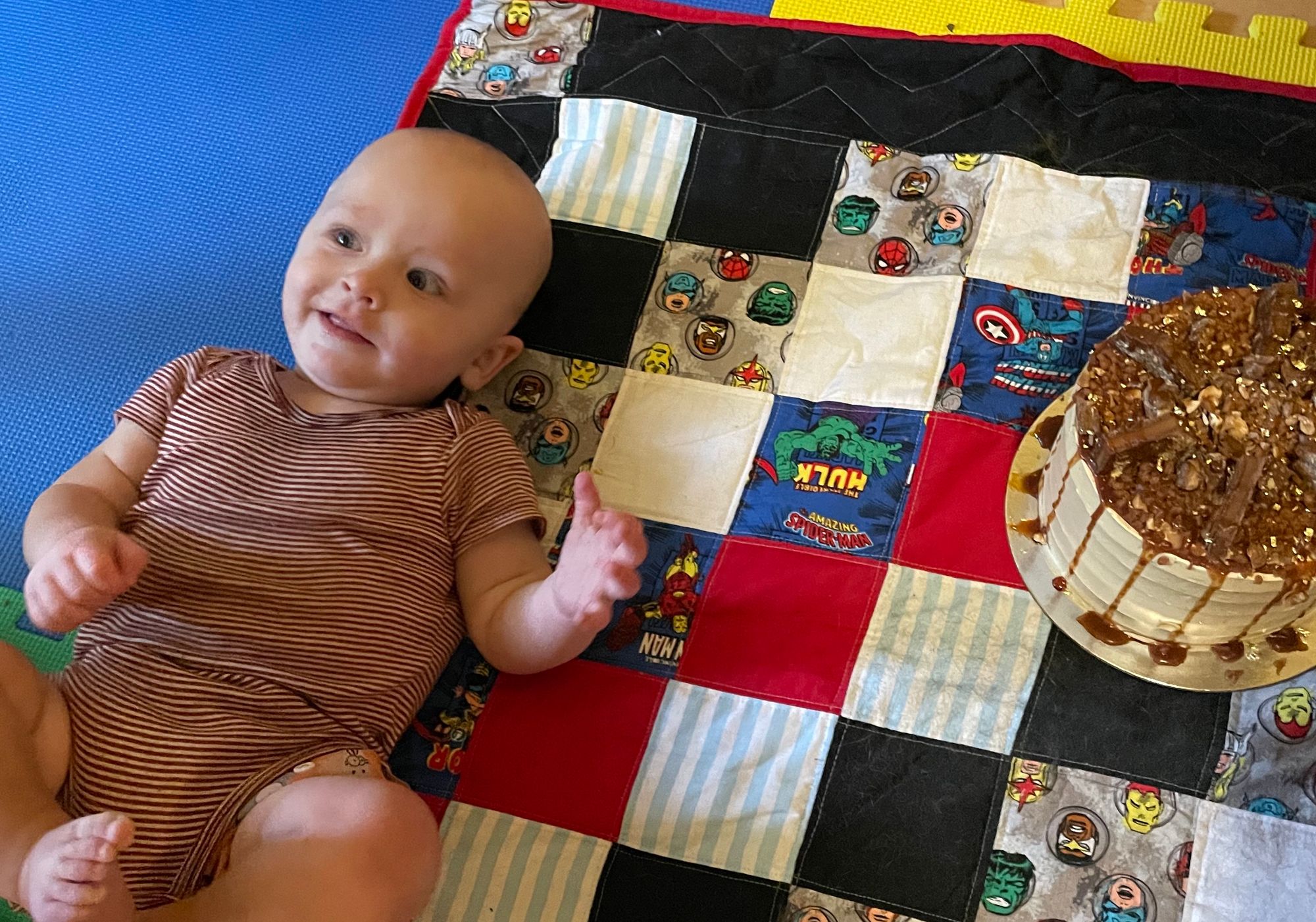 Freddie is looking off-camera as he is posed next to another cake.