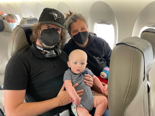 A couple holding a baby on a plane.